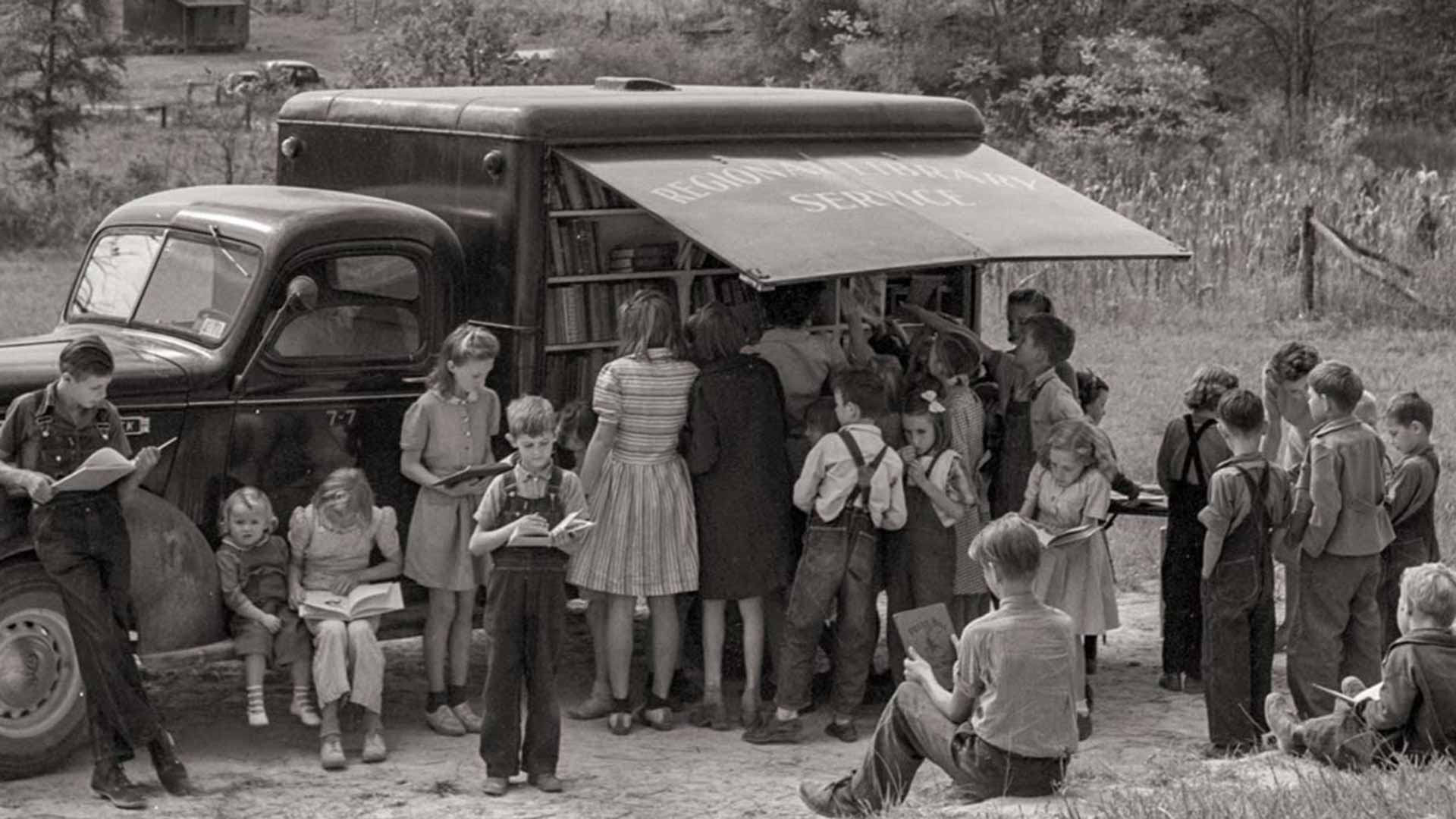 A group of citizens outside the truck reading.