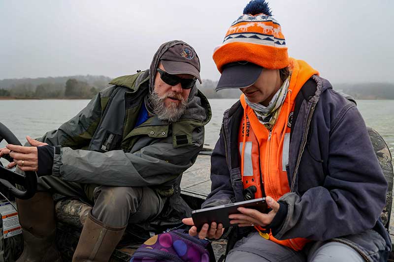 People in coats and hats looking at tablet