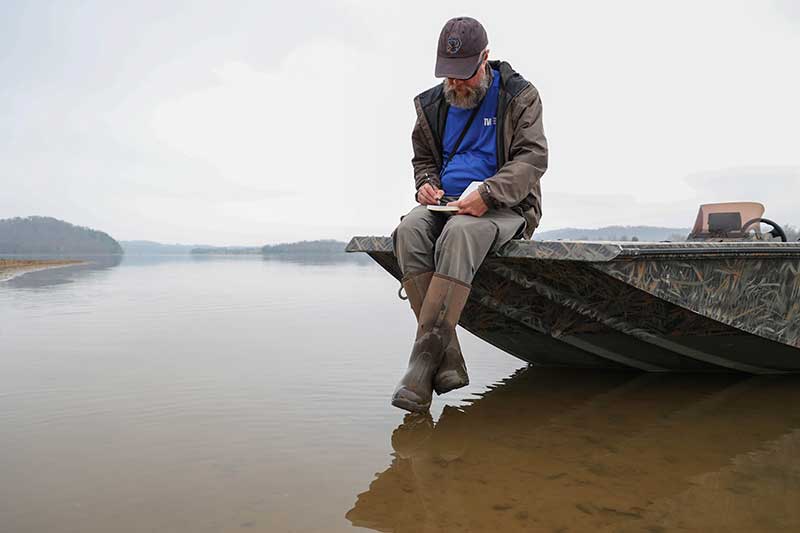 Person sitting on boat and dangling feet over water's surface