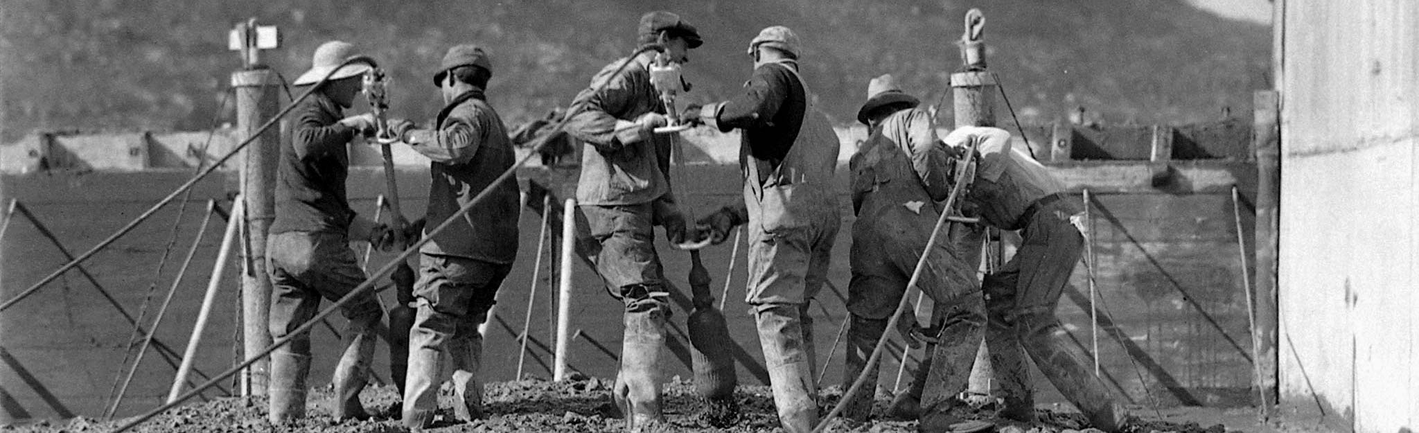 Historic photo of workers on a construction site handling ropes and equipment