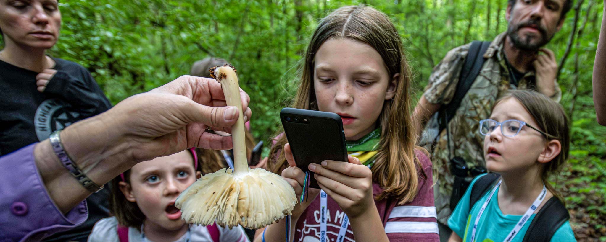 A group of children and adults inspect a fungus during the BioBlitz event at Norris Lake.