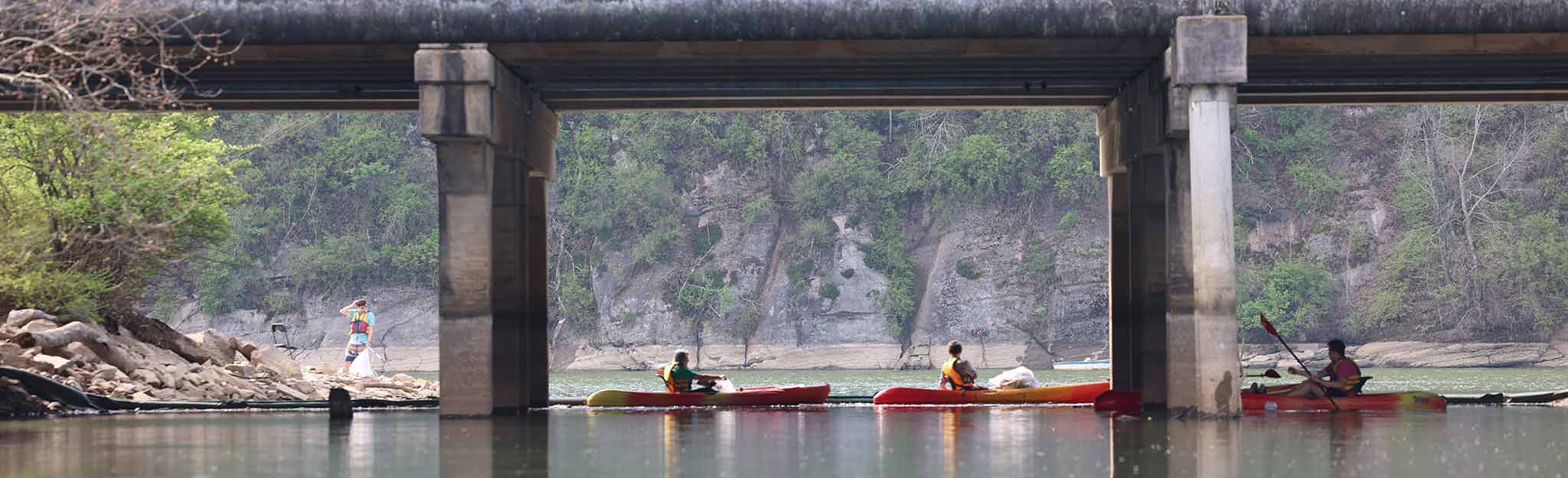 Kayaks on water under bridge