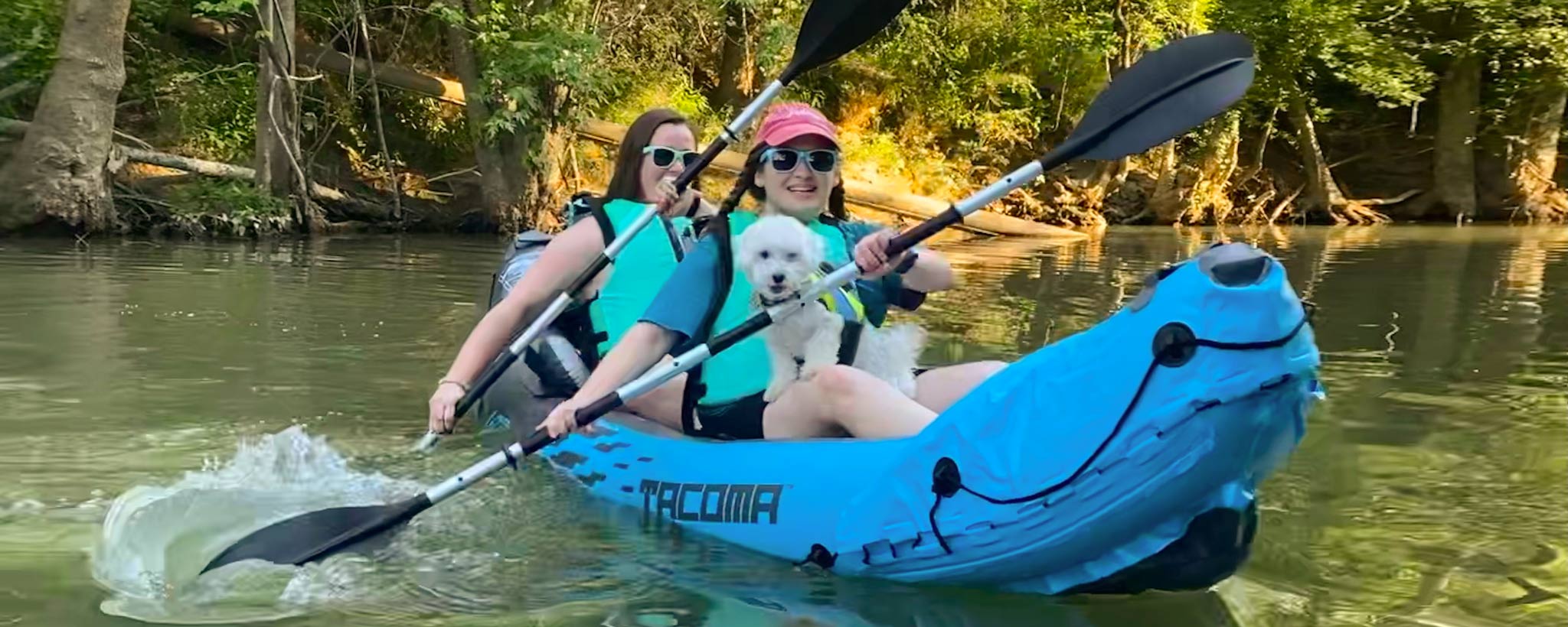 Mother and daughter kayaking with dog
