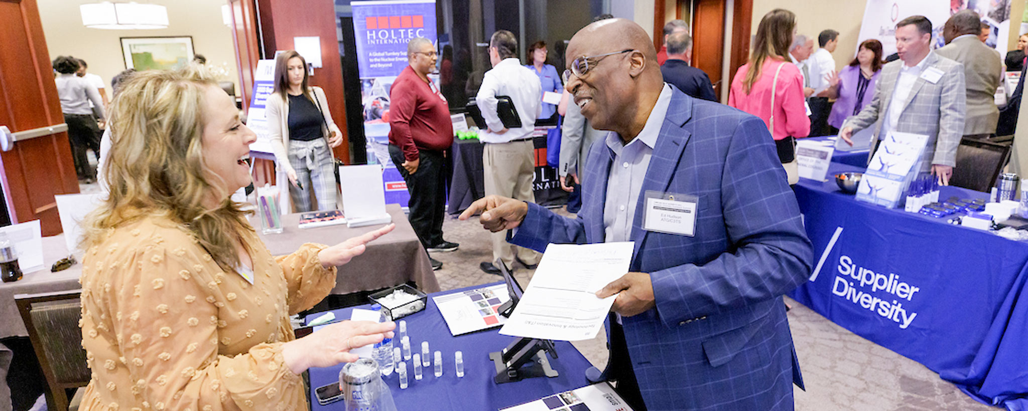 Guests at Supplier Diversity Summit A guest visits at booth at the Supplier Diversity Summit