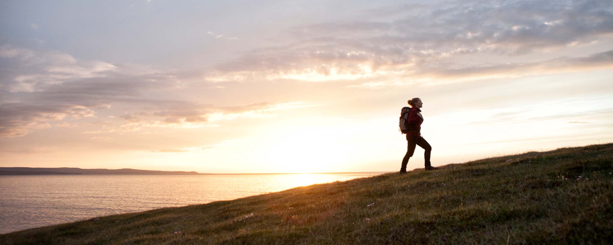 Hiker by lake at sunrise