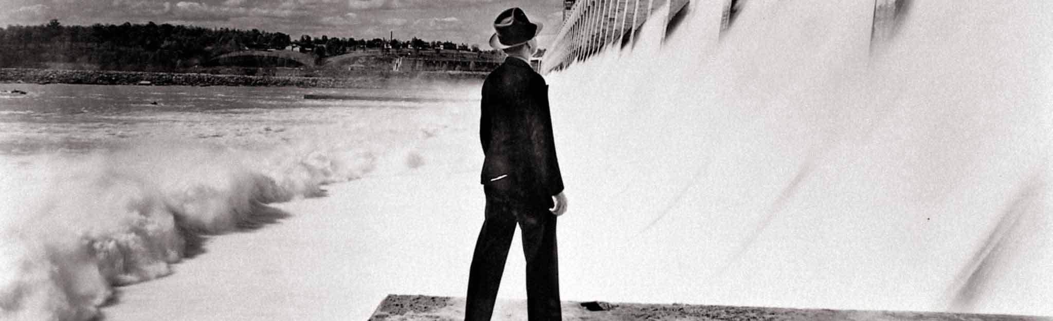 TVA Chairman David Lilienthal standing before a TVA dam
