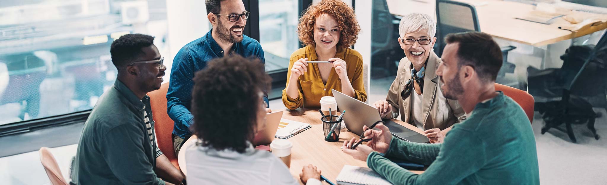 Mixed group of business people sitting around a table and talking