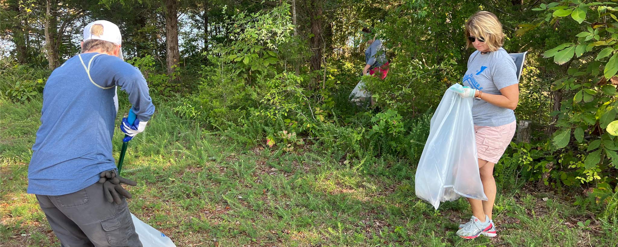 volunteers picking up trash from a campsite on Pilot Island in Lake Norris