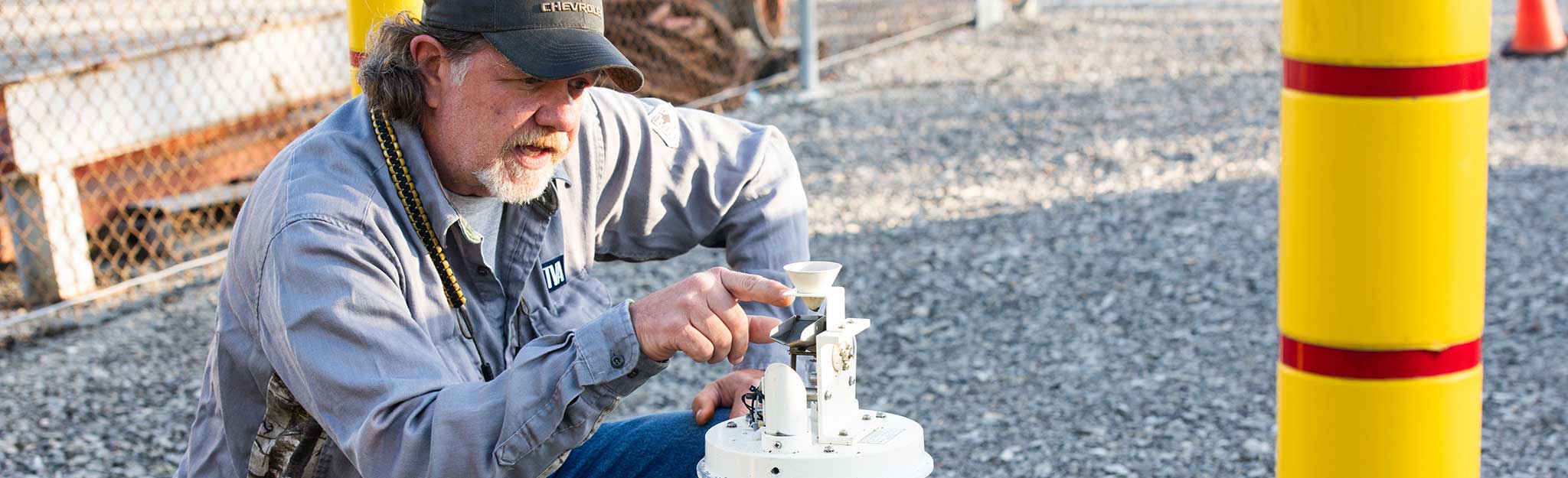 TVA senior instrument mechanic Ralph Nunley explains the tipping mechanism in a rain gauge