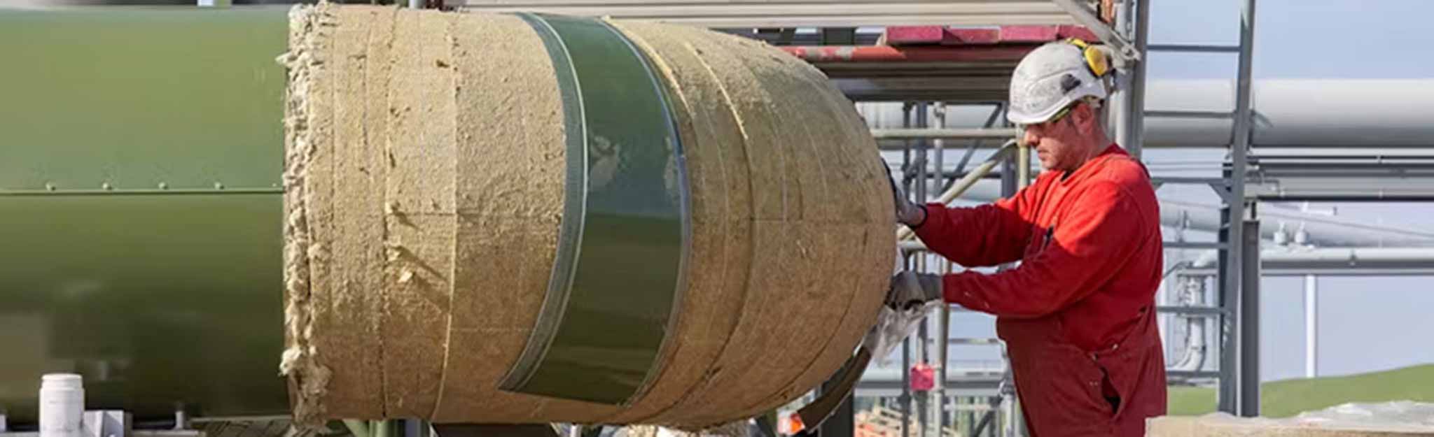 A worker installs Rockwool insulation. A worker installs Rockwool insulation.