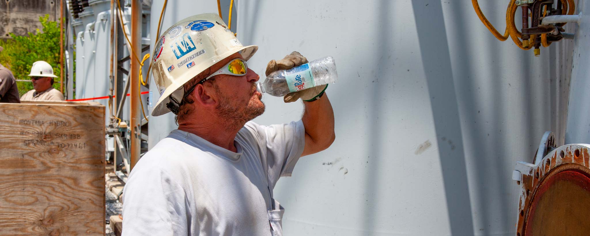 Electrician drinking water on a hot summer day Electrician drinking water on a hot summer day