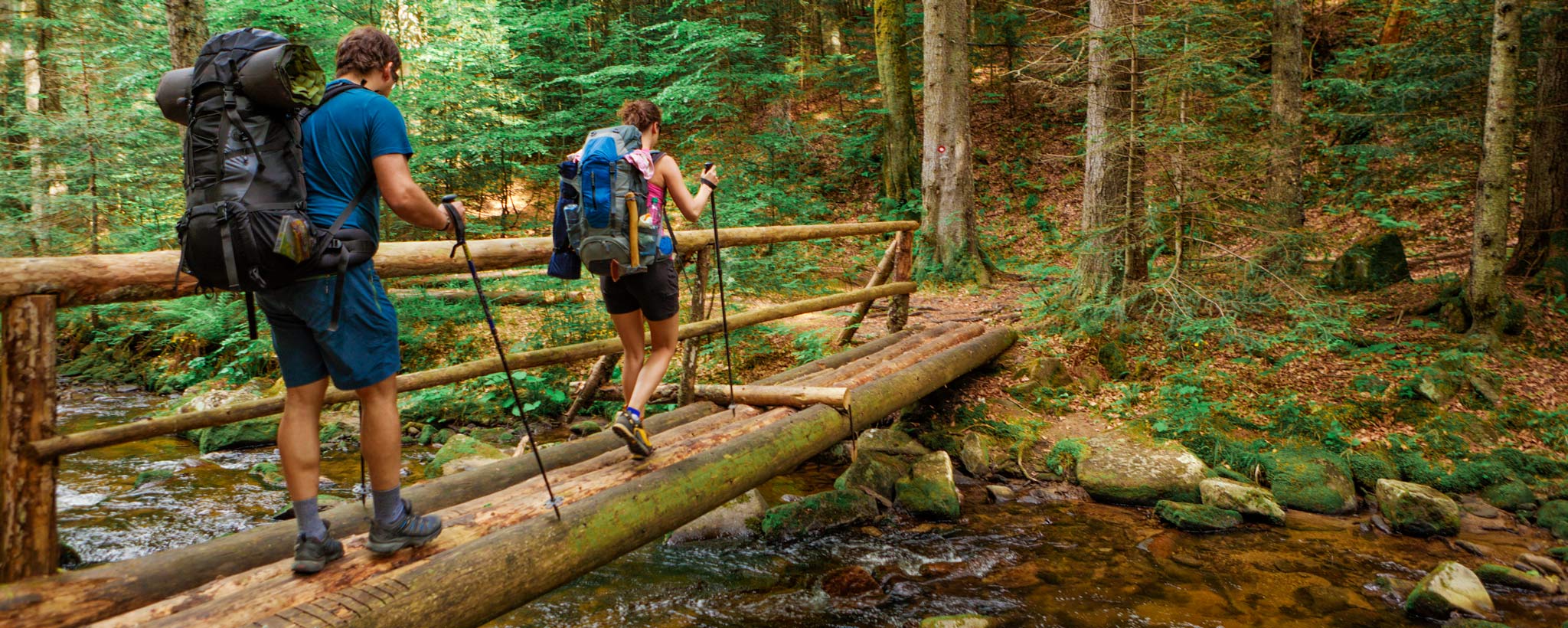 trail-safety-hero-GettyImages-175487339 hikers crossing footbridge
