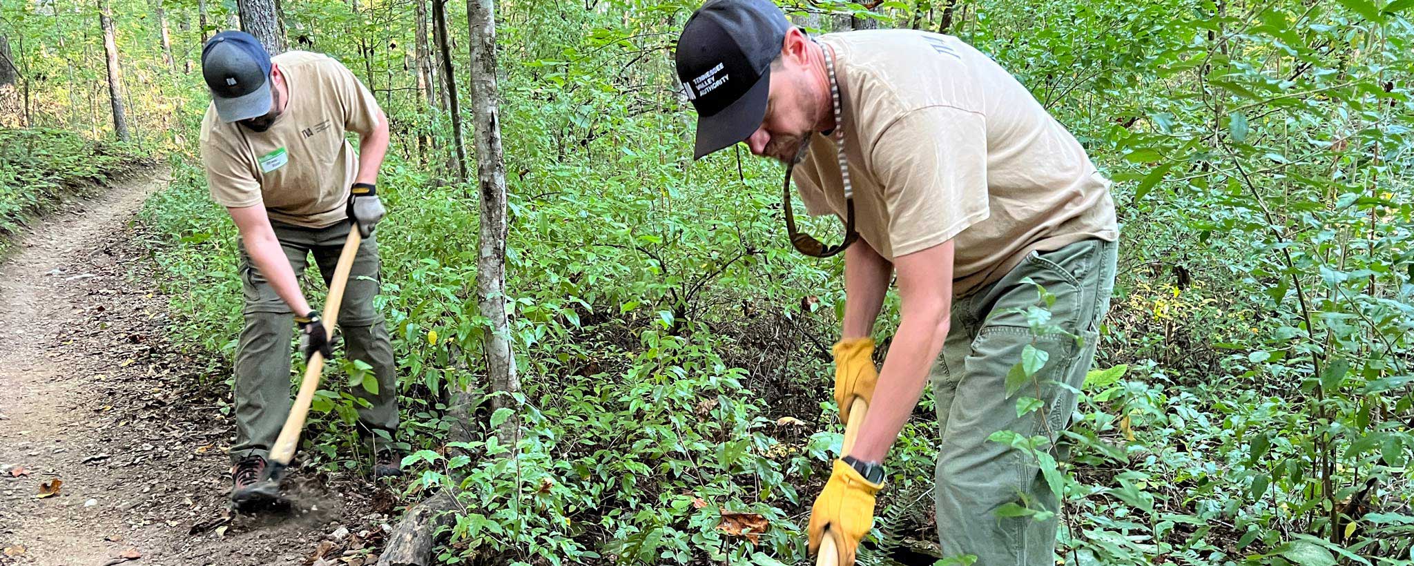 TVA Team Two TVA team members use digging implements to clear a trail’s edge at Loyston Point during the National Public Lands Day activities