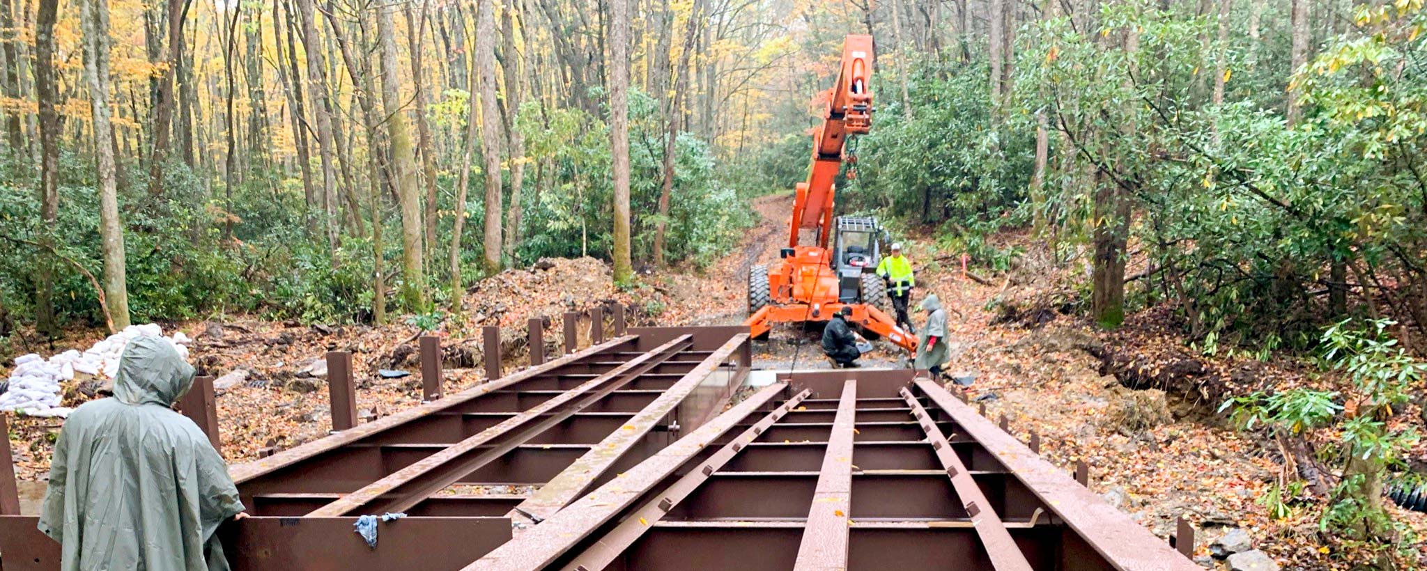 Wolf Creek Bridge Workers use heavy machinery to position beams for the new Wolf Creek bridge