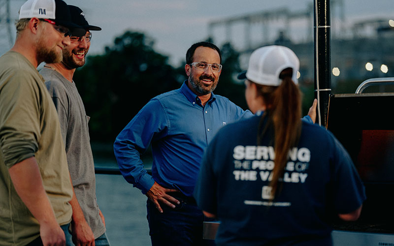 Tow boat captain Shane Carmen talks with members of the Freedom crew