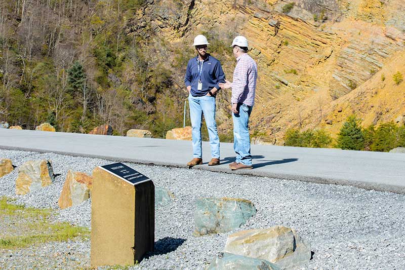 Clark and Bell chat at the top of the rockpile dam near the Watauga commemorative plaque.