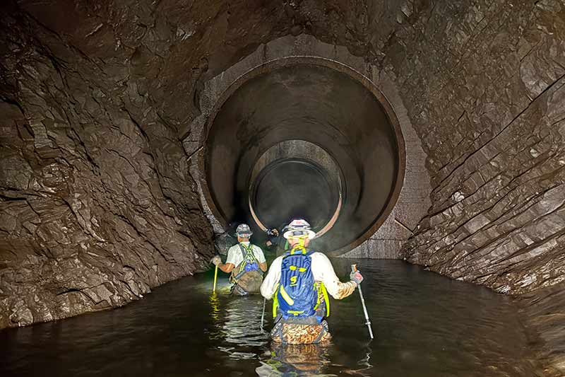 Dam Safety crew members in the penstock, which stretches 3,700 feet through Iron Mountain.