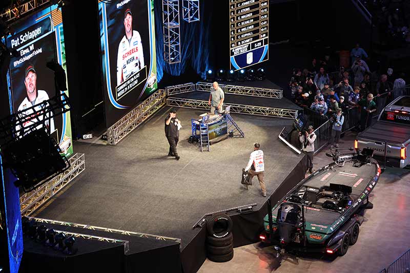 Bassmaster contestent walks onto stage for weighing his catch