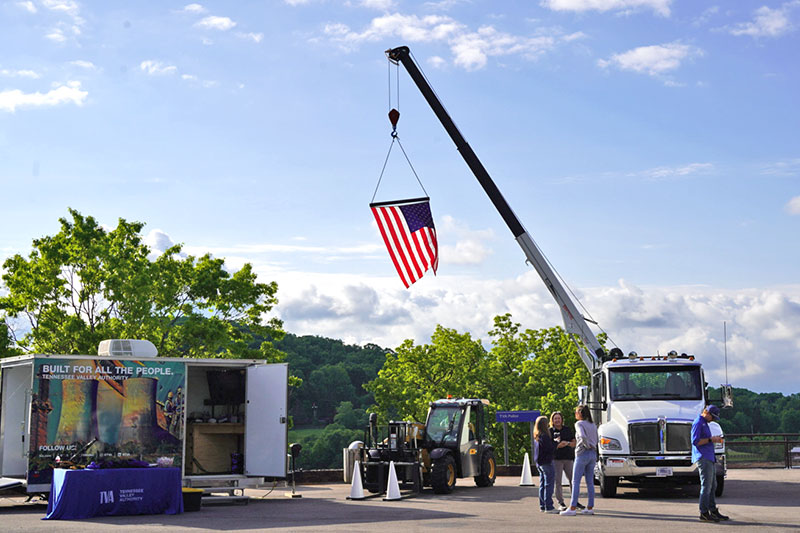 TVA's Equipment Support Services brought heavy machinery and suspended a large flag from the bucket truck.