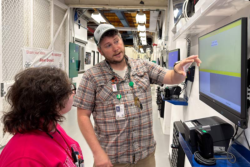 Chad Dozier shows a screen to a colleage.