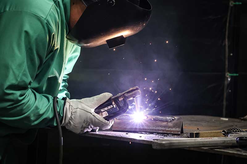 Welder with helmet working on a project