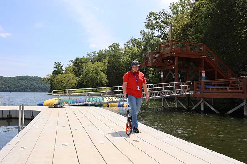 A member of TVA's Public Land Management team measures a dock as part of the permitting process