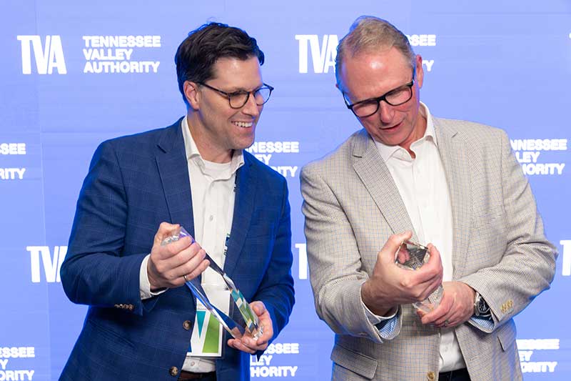 Two winners look at awards.