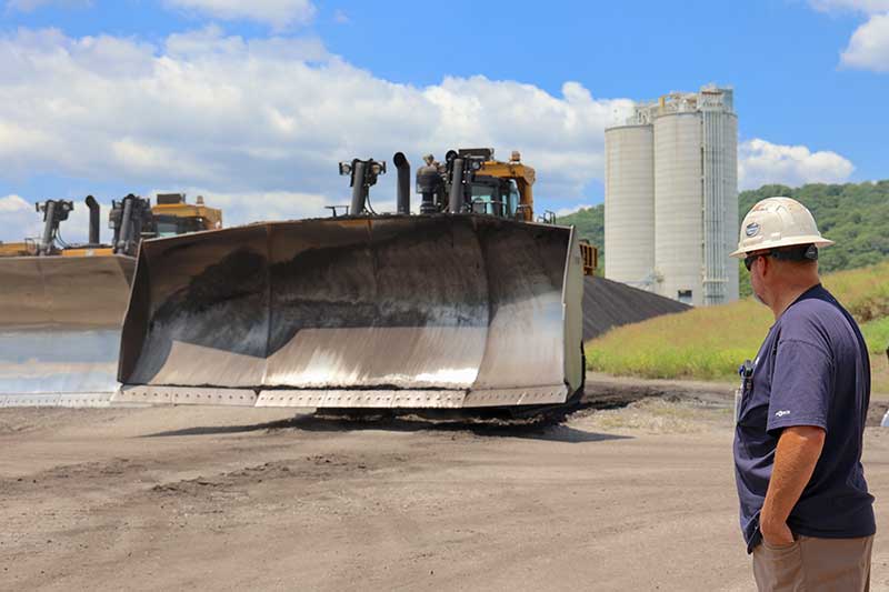 TVA heavy equipment operator Jeff Dalton watches as a large bulldozer works to mix and move coal at the Kingston Fossil Plant.