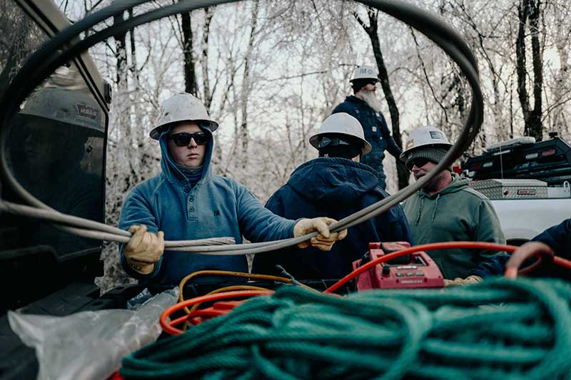 Lineworker holding a loop of heavy wire for a powerline repair