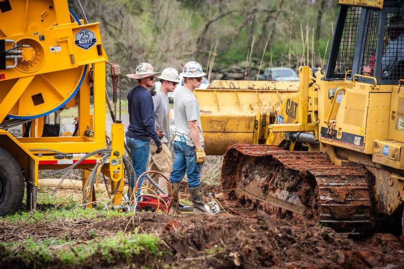 Lineworkers surrounded by heavy equipment