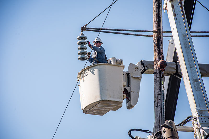 Josh Hinch adjusts an insulator from a bucket.