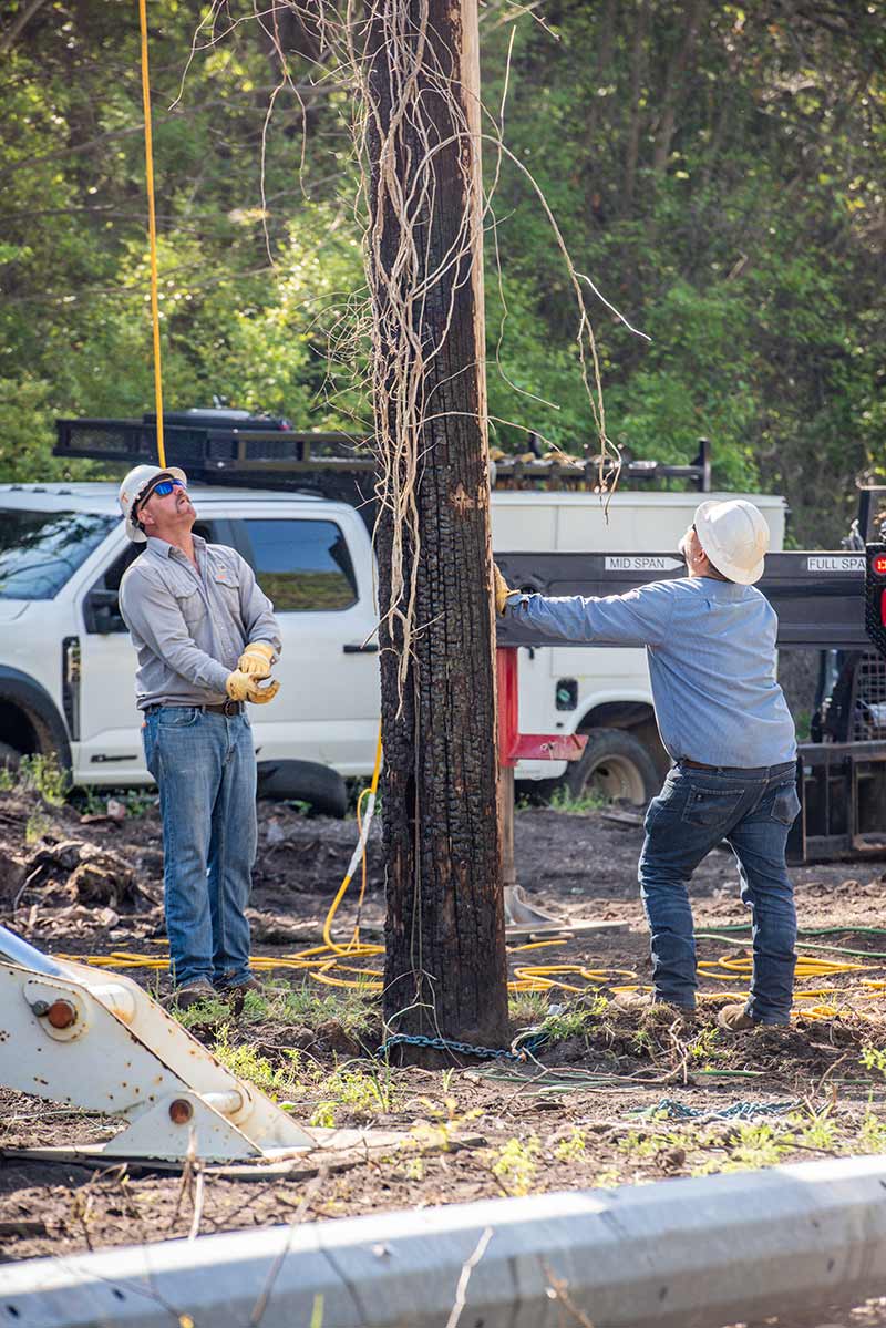 Simmons and Hayes ready a wood pole for replacement.
