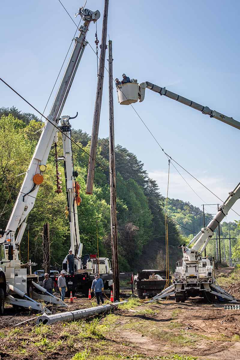 The maintenance crew cuts and removes a wood pole that will be replaced with a steel pole.