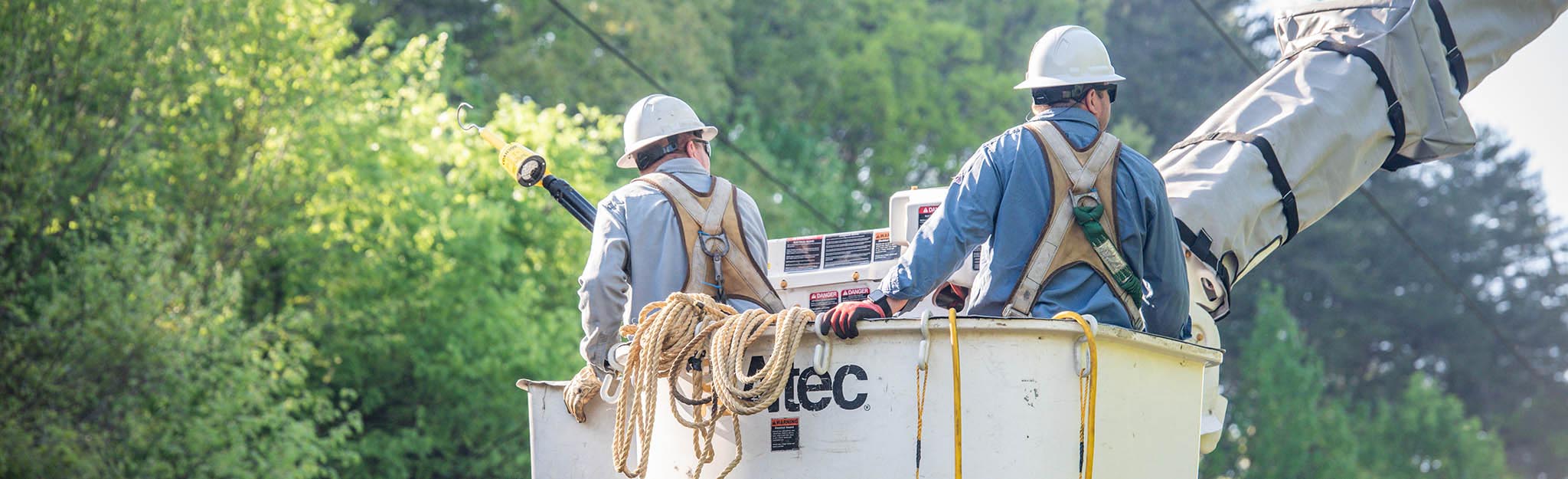 Two lineworkers in a bucket truck