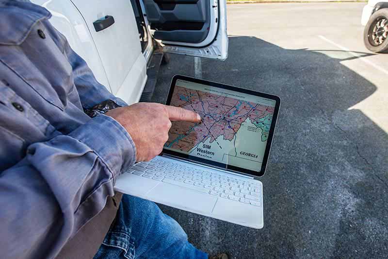 Pointing to a map of rain gauge locations on a laptop screen
