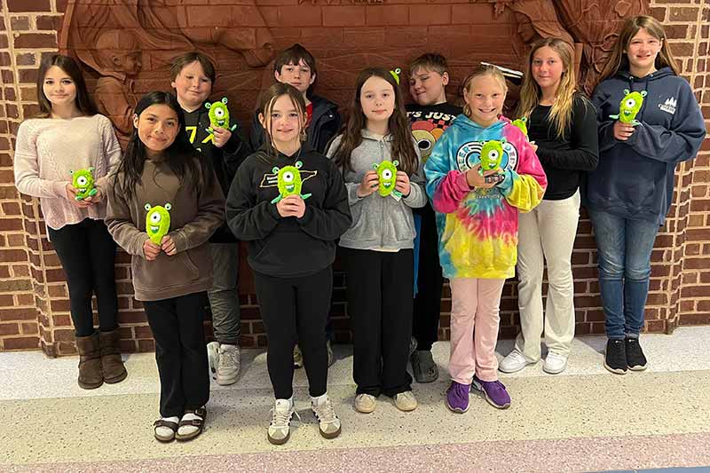 Students holding energy monsters