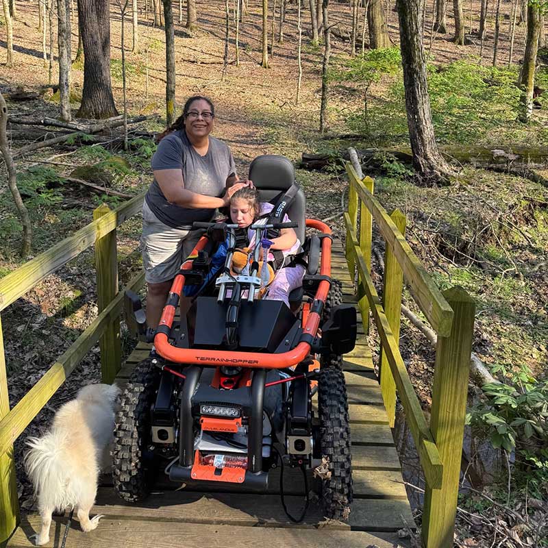 Serinity Hartman and her mother enjoy the outdoors with a specialized TerrainHopper to navigate trails.
