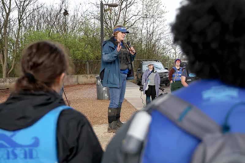 Person talking into mic surrounded by volunteers
