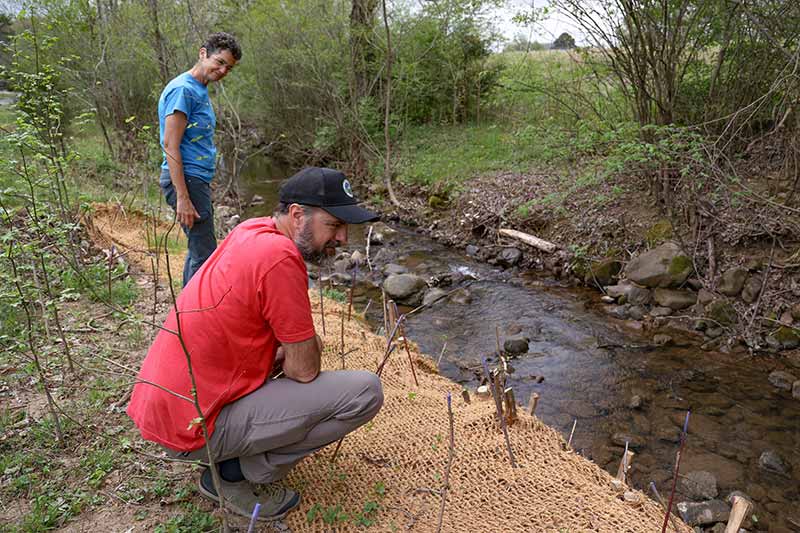 Man kneeling by streambed