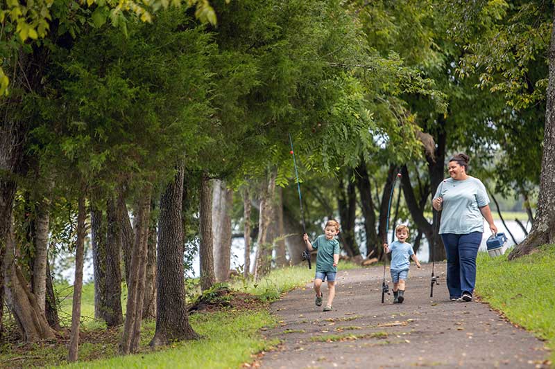 Family walking along path with fishing poles