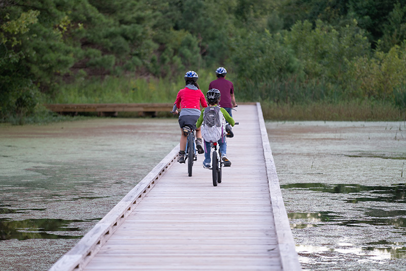 Bikers on the boardwalk on the Marbut Bend Trail in Alabama.