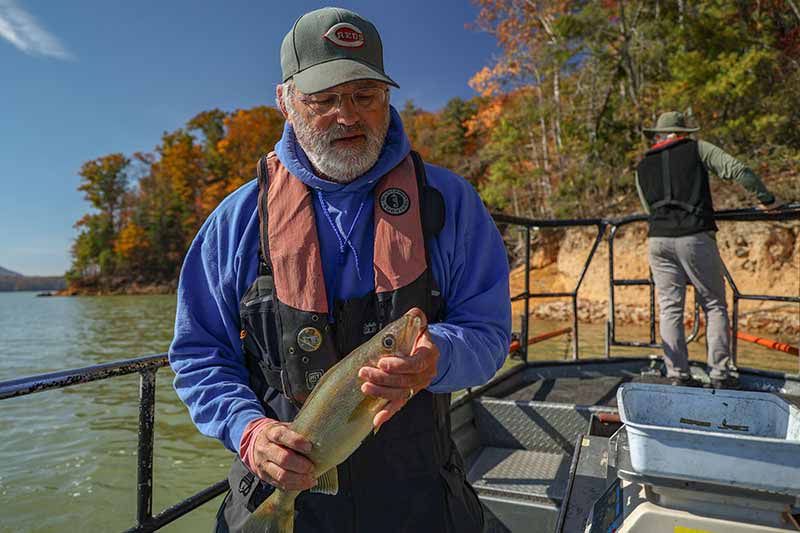 Man on boat holding fish