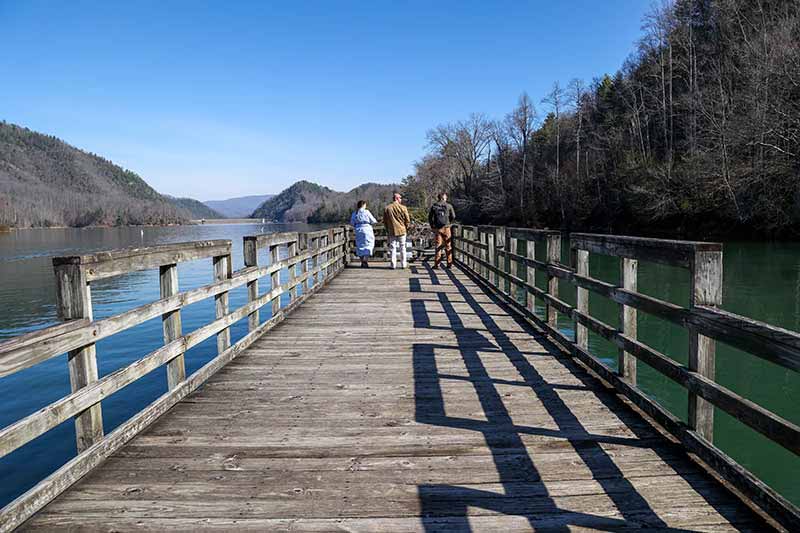 Three men walking down fishing pier