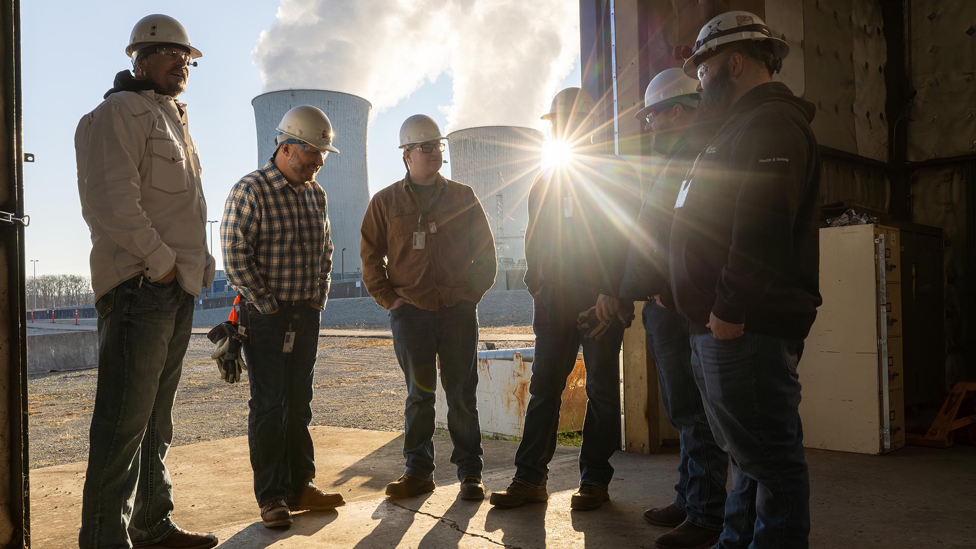 TVA employes standing together with cooling towers in the background