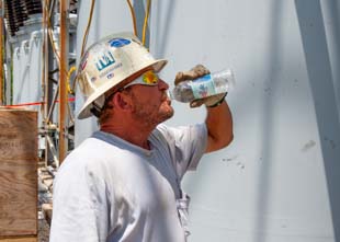 Electrician drinking water on a hot summer day