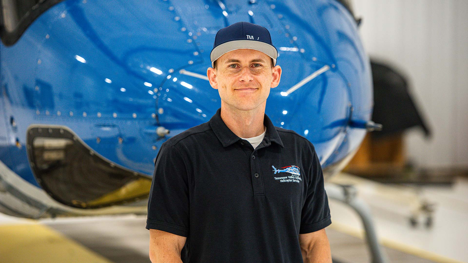 TVA pilot Peter Kretowski stands in front of a helicopter
