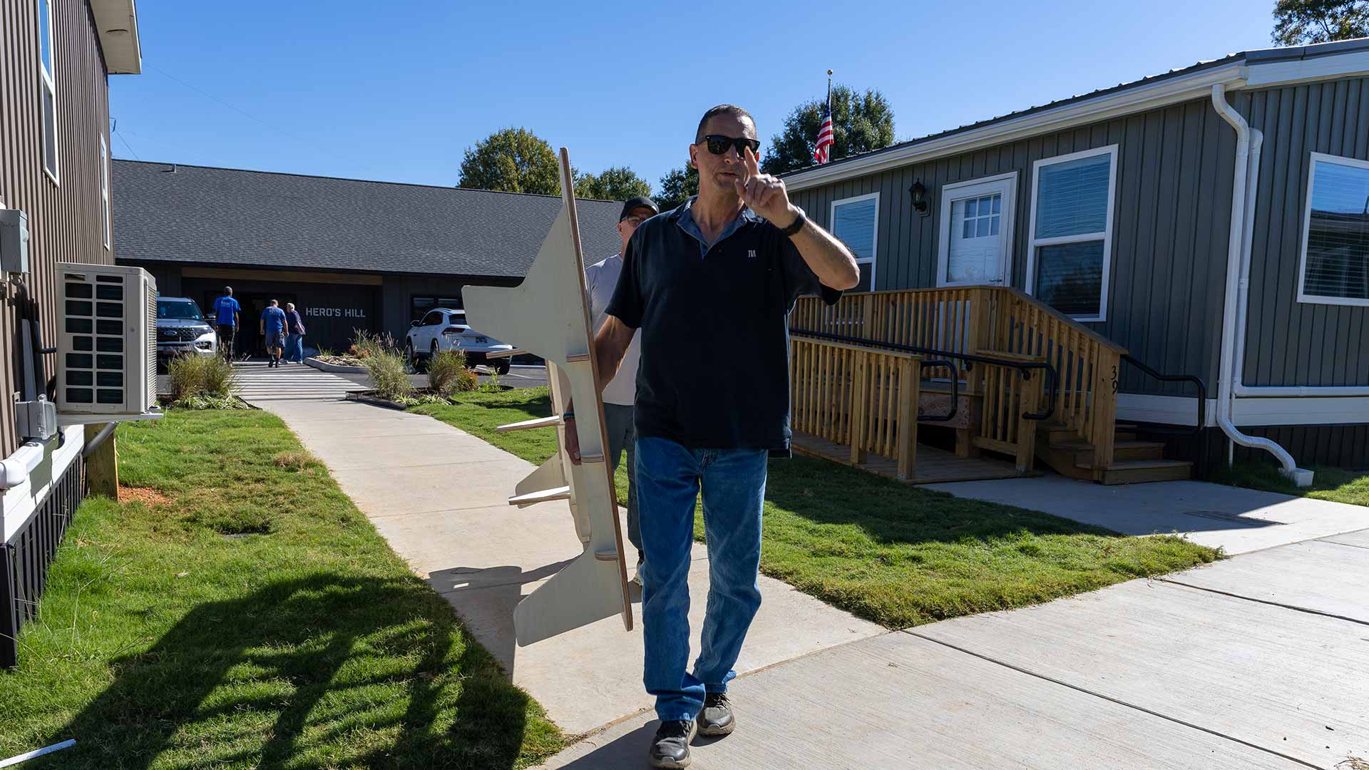 TVA volunteer carries a bed to a tiny home that will soon welcome a Veteran in need of a new home.