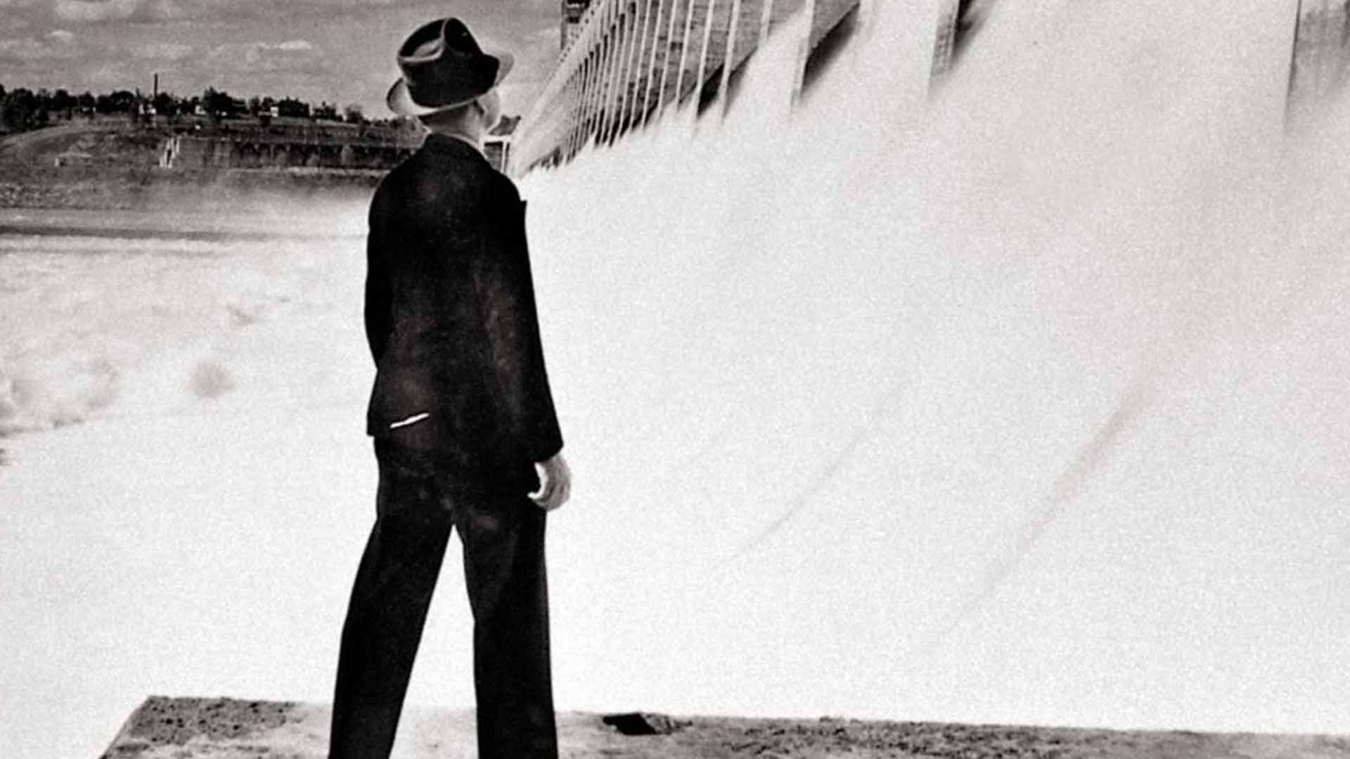 TVA Chairman David Lilienthal standing before a TVA dam