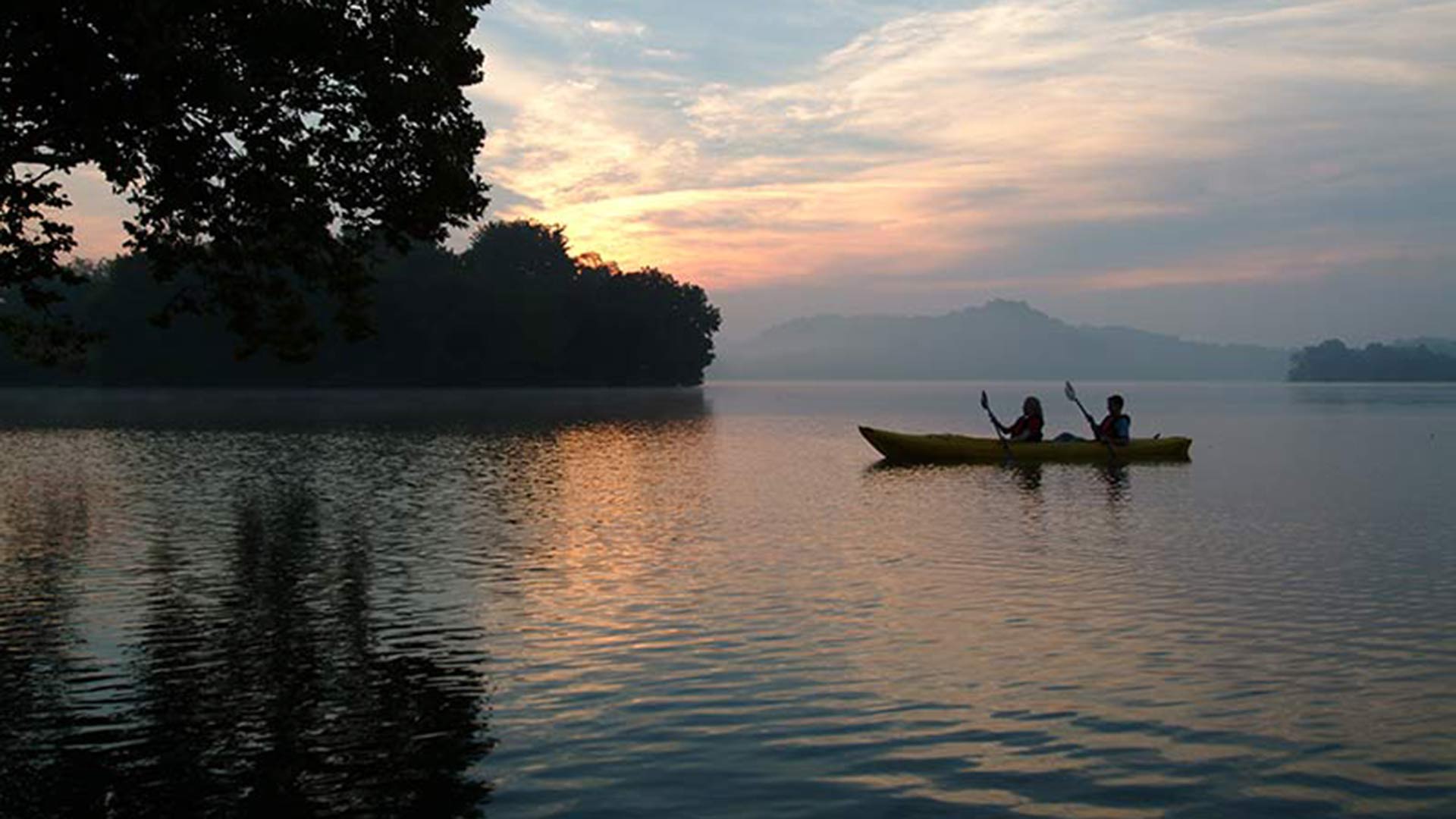 Canoeing on lake at sunset