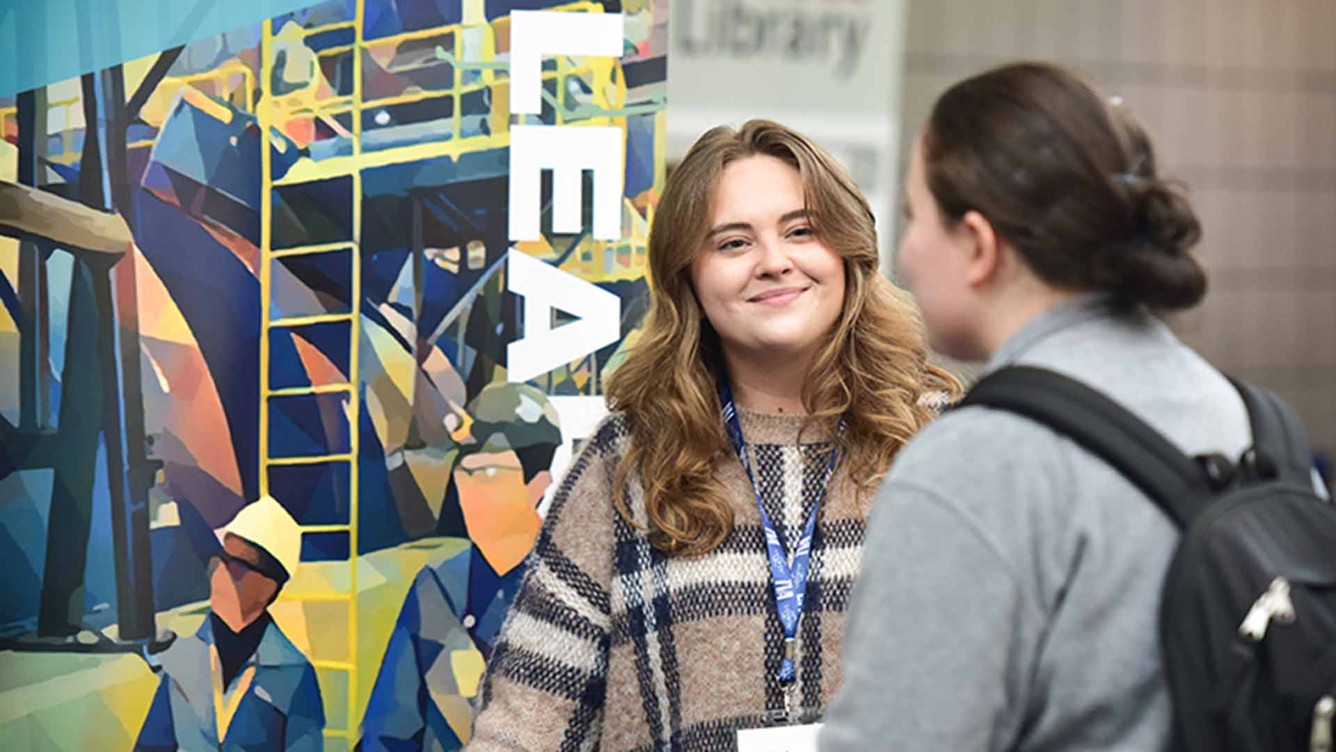 Chloe Grigsby talks with a student at a Roane State Community College career fair